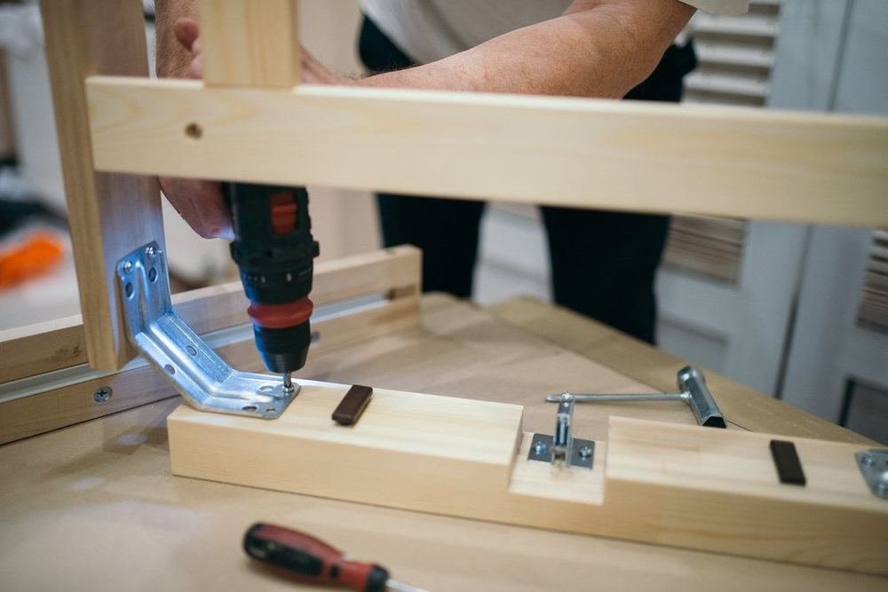 Montaggio di un mobile con avvitatore durante un trasloco